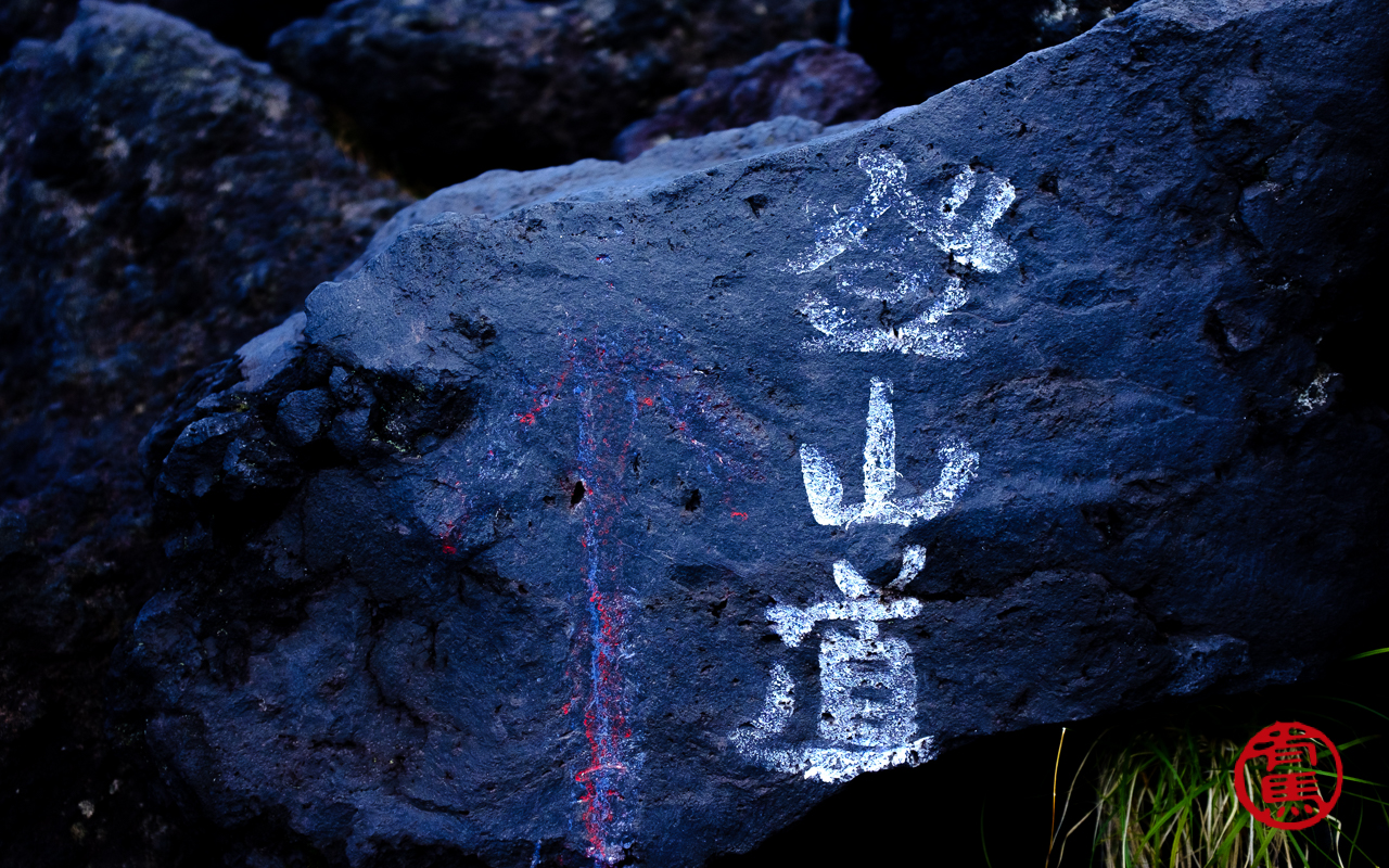Antiga sinalização da trilha em japonês escrito: caminho para subir a montanha.